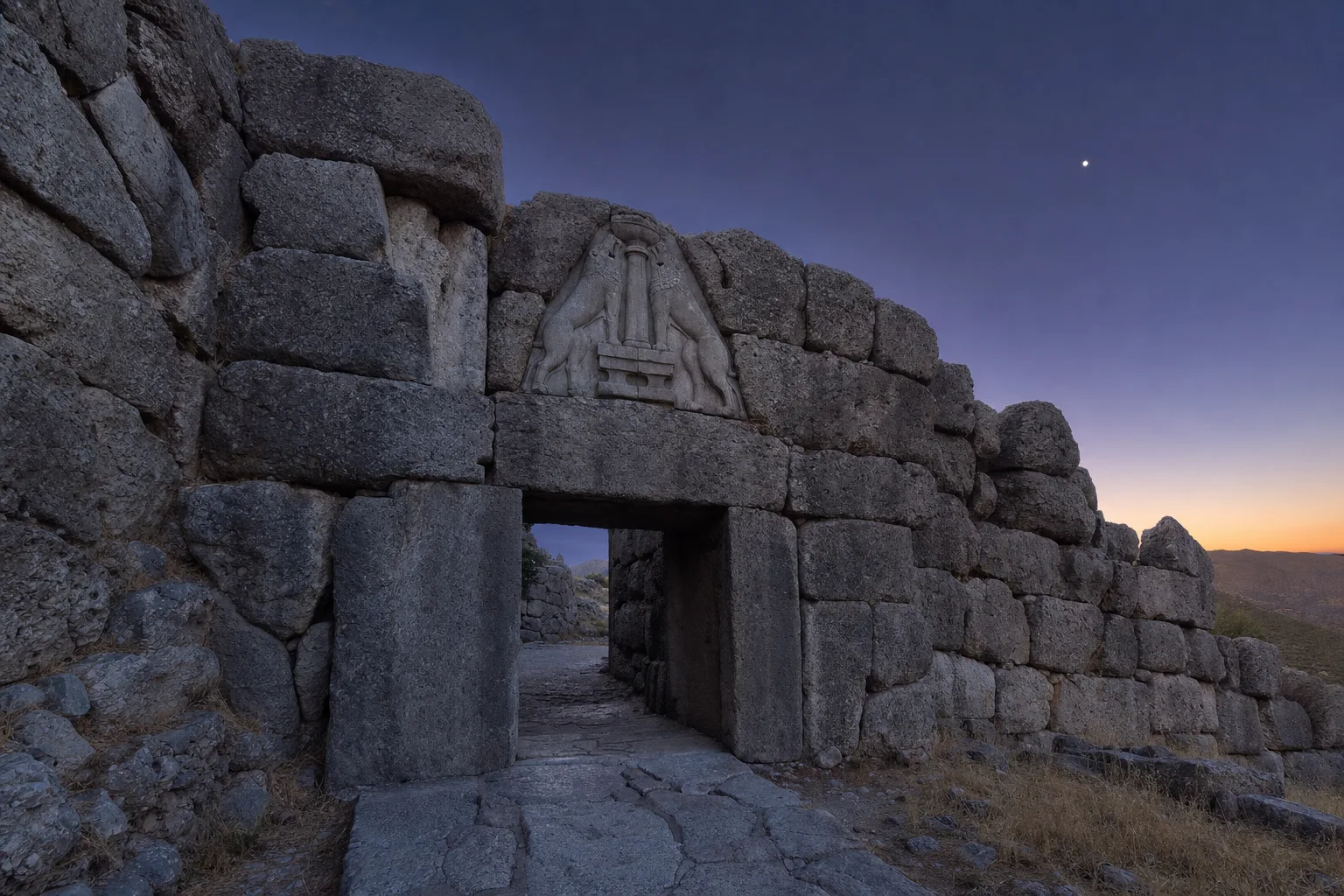 Massive stone gateway at dusk with two lionesses carved in relief flanking a central column above the lintel, the evening star in a violet sky